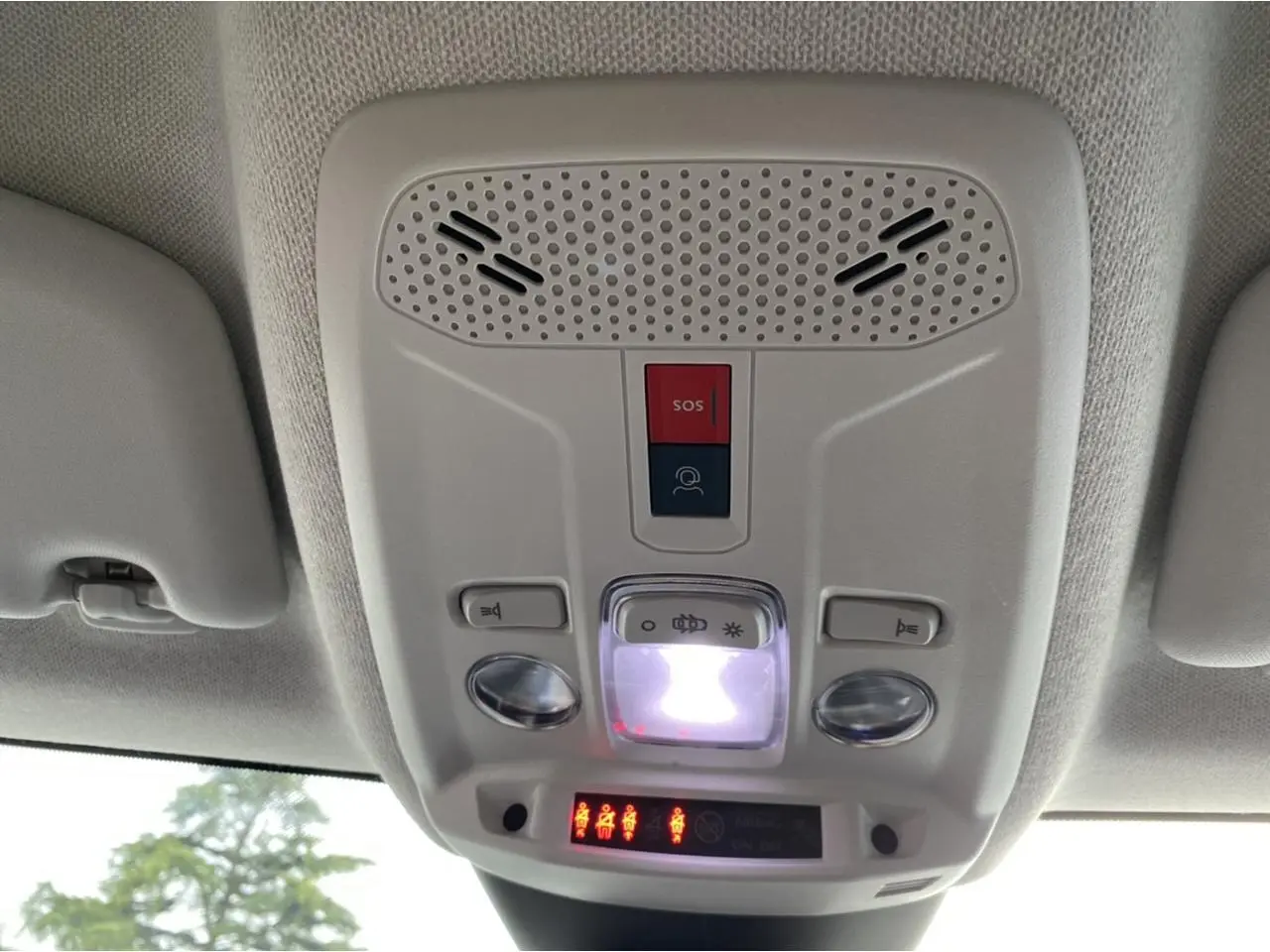 Vue du plafonnier intérieur gris clair du Citroën C4 2021 avec boutons SOS et éclairage central allumé.