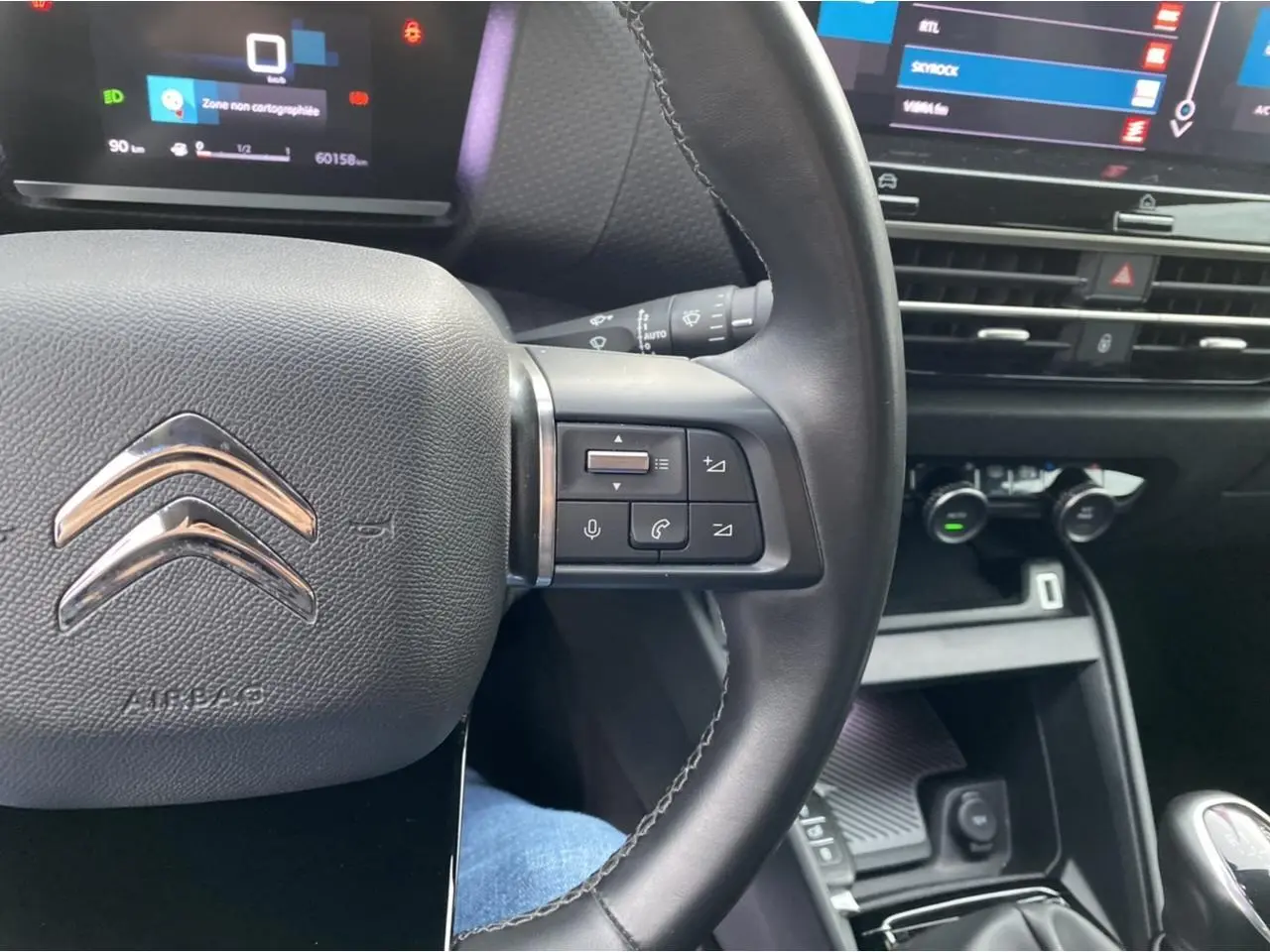 Gros plan sur le volant et la console centrale de la Citroën C4 2021, mettant en valeur les commandes au volant et l'écran tactile.