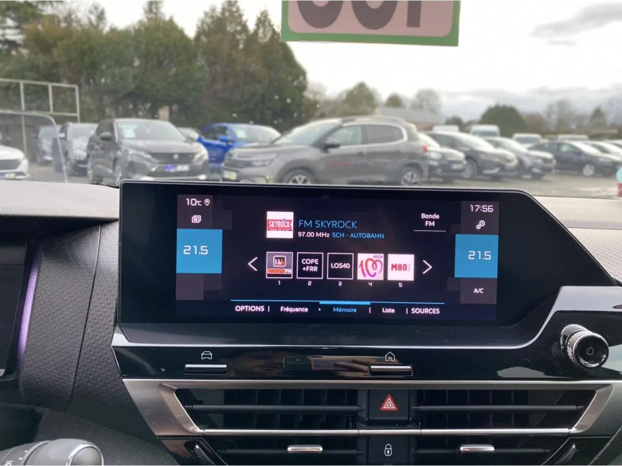 Écran tactile central du tableau de bord d'une Citroën C4 2021, affichant la radio FM Skyrock et la climatisation à 21,5°C.