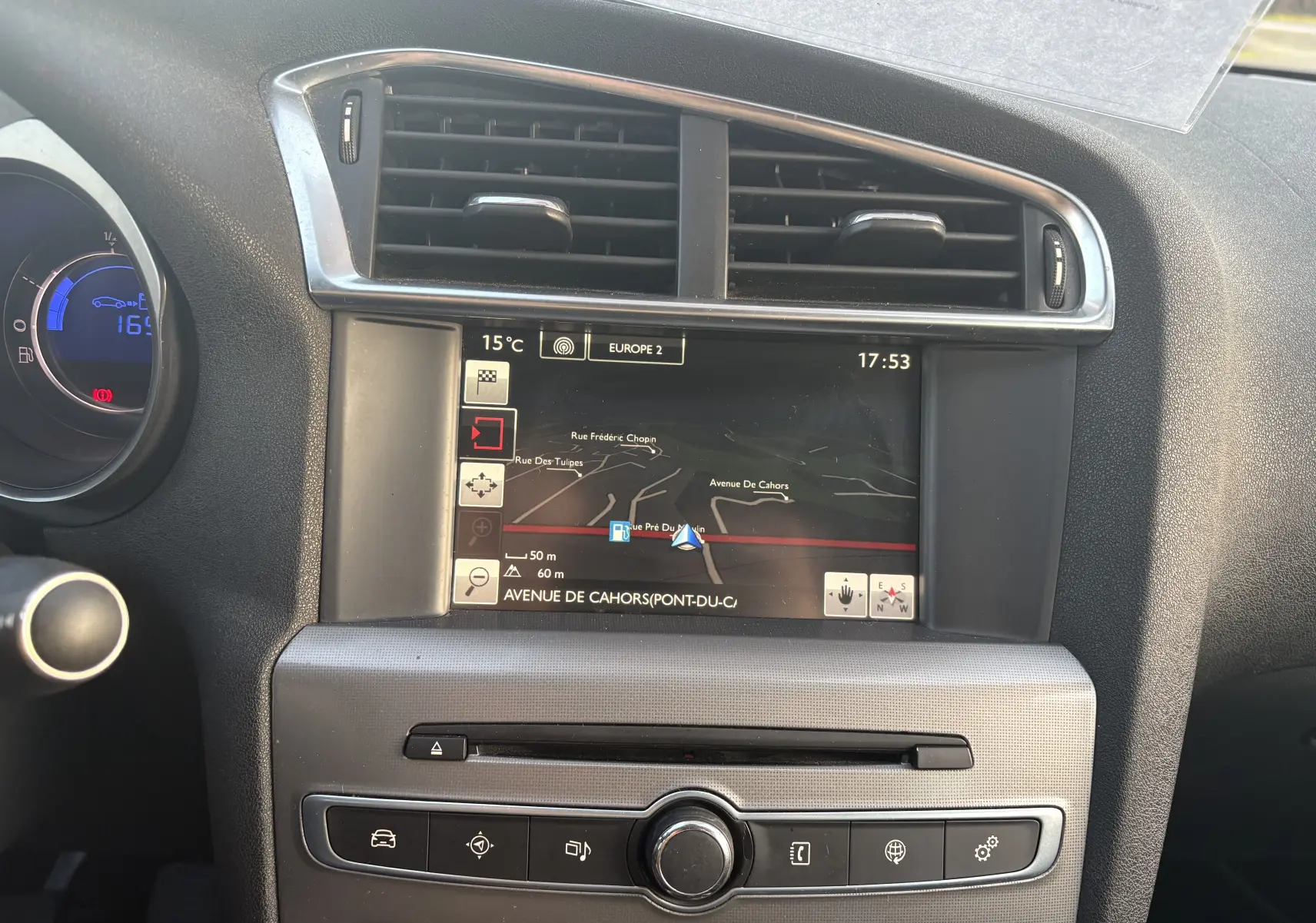 Vue rapprochée du tableau de bord de la Citroën C4 II 2.0 HDI 150 Hybride 2015 avec écran GPS et commandes climatisation.