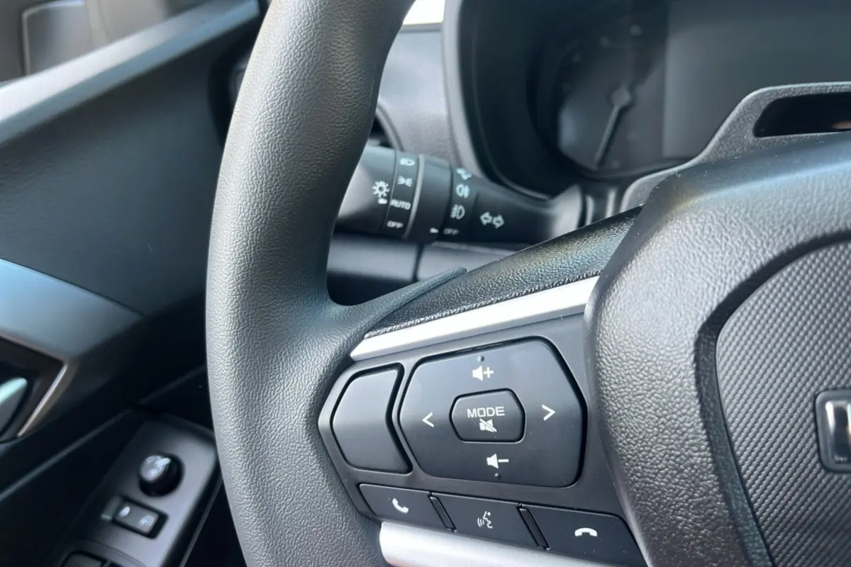 Gros plan sur le volant multifonctions côté gauche de l'Isuzu D-MAX 2026, boutons de commande audio et téléphone visibles.