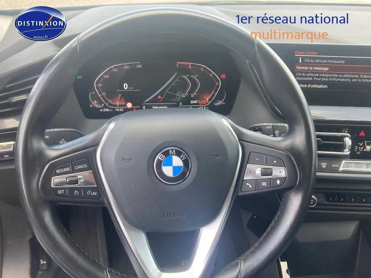 Vue rapprochée du volant cuir noir multifonction et tableau de bord numérique de la BMW Série 1 118i 2023.