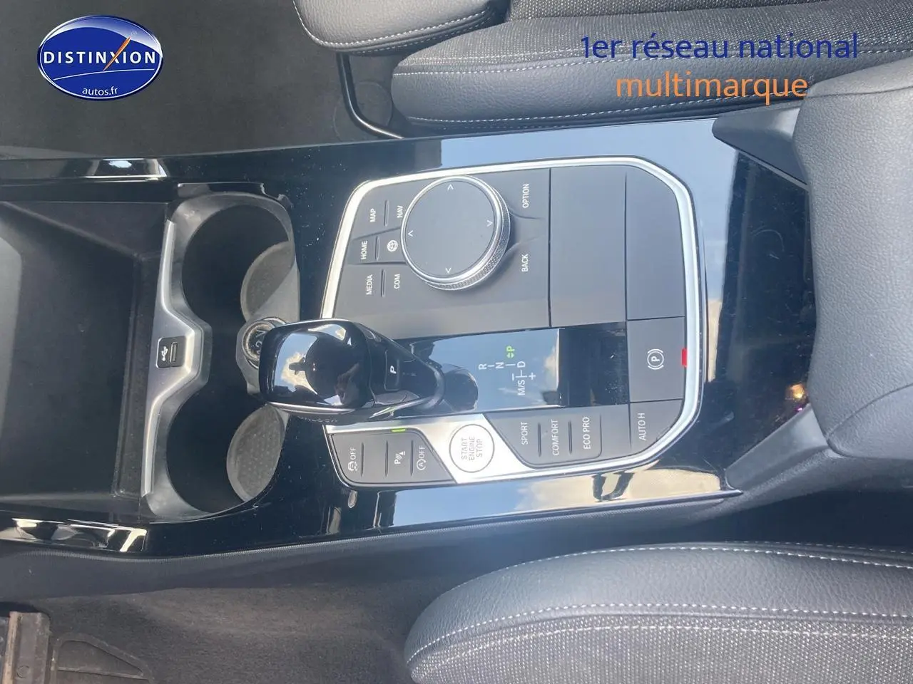 Vue rapprochée de la console centrale noire brillante de la BMW Série 1 118i 2023 avec levier de vitesse automatique et commandes.