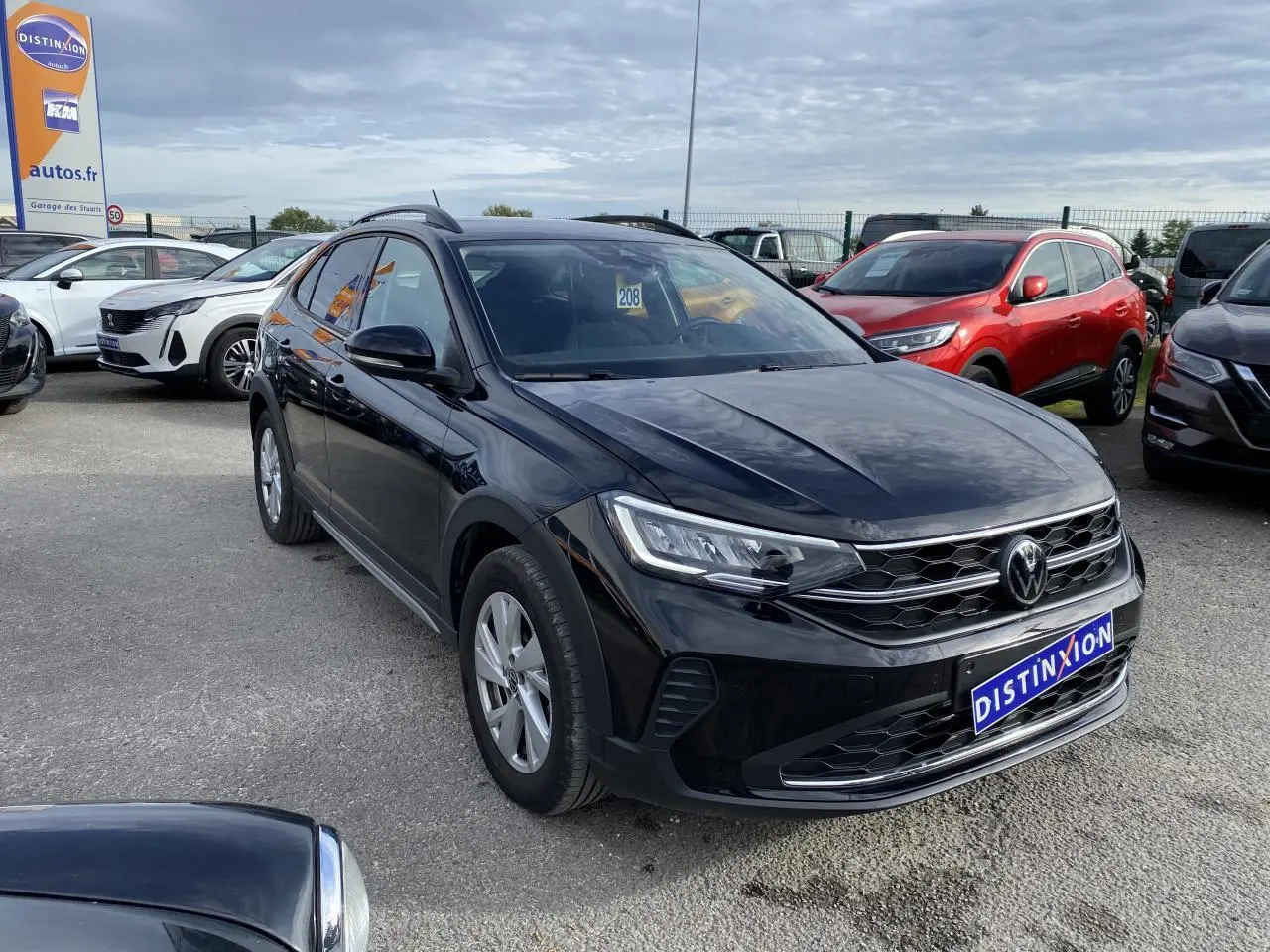 Volkswagen Taigo noir intense vu en 3/4 avant droit sur parking avec calandre et phares LED visibles.