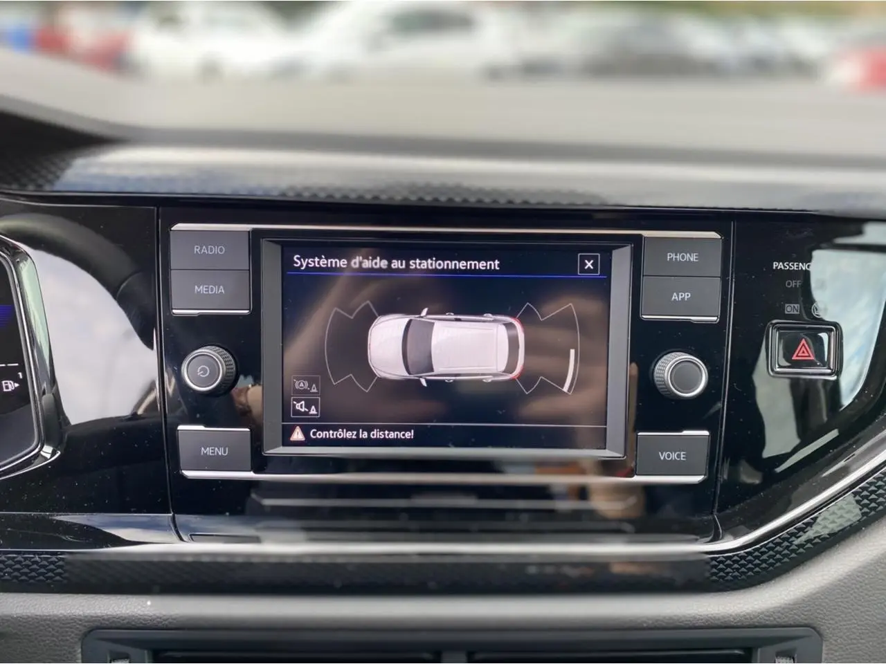 Écran tactile central du Volkswagen Taigo 2022 affichant l'aide au stationnement dans un intérieur noir brillant.