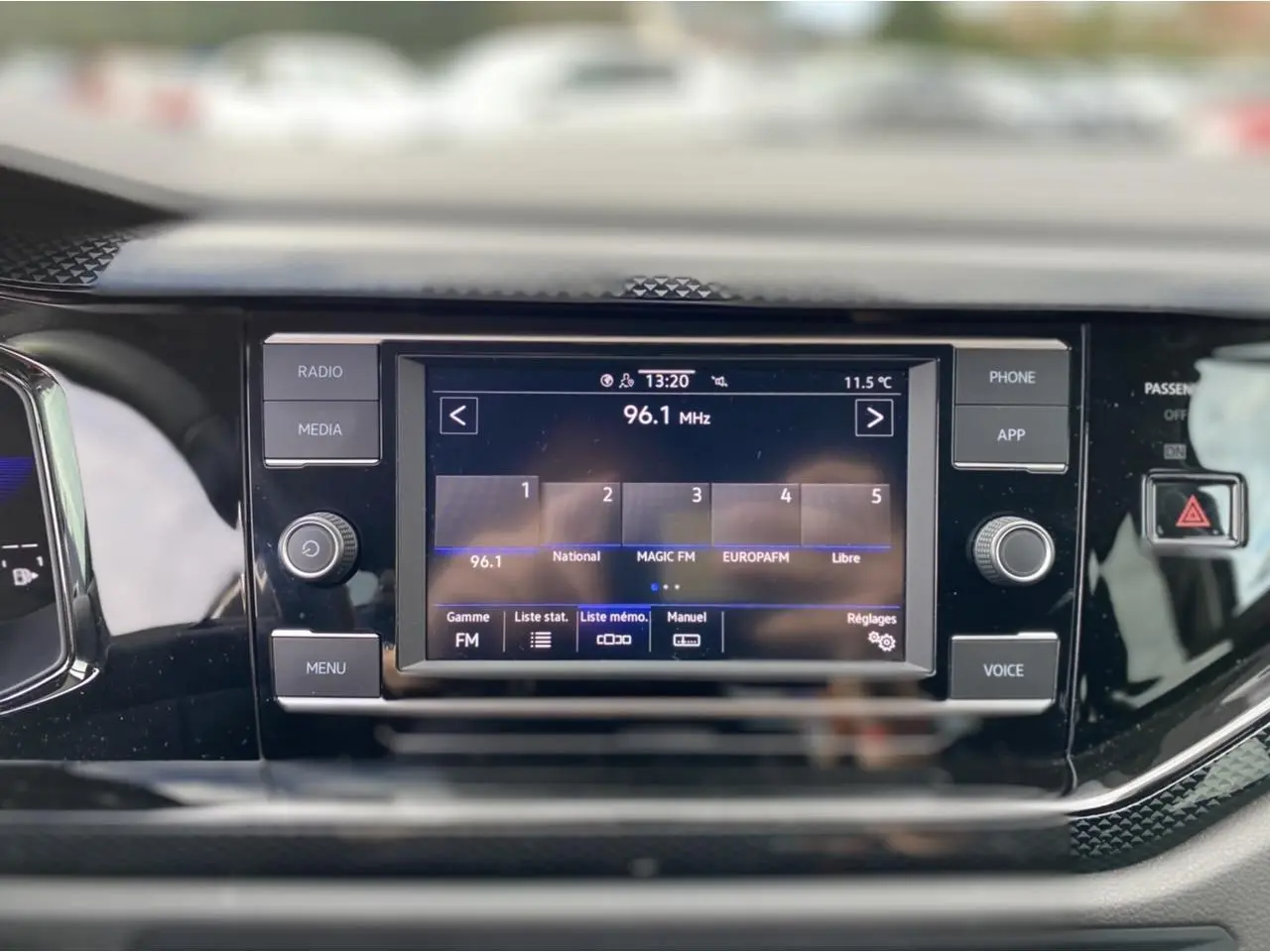 Écran tactile central 8 pouces du Volkswagen Taigo 2022 affichant la radio FM, entouré de commandes noires brillantes.