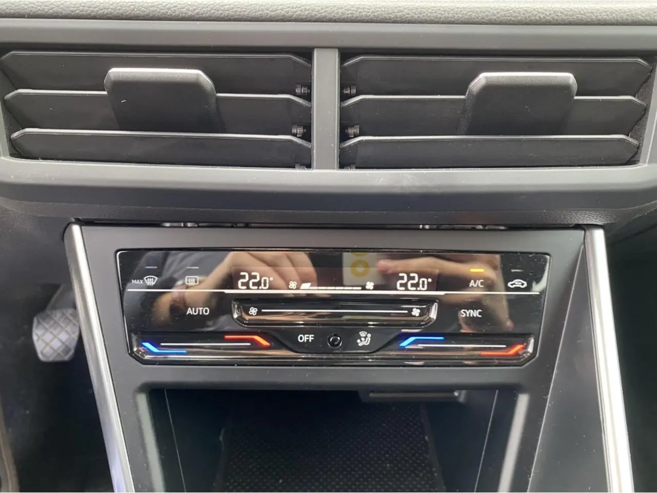 Détail de la console centrale du Volkswagen Taigo 2022 montrant la climatisation automatique bi-zone à 22°C.