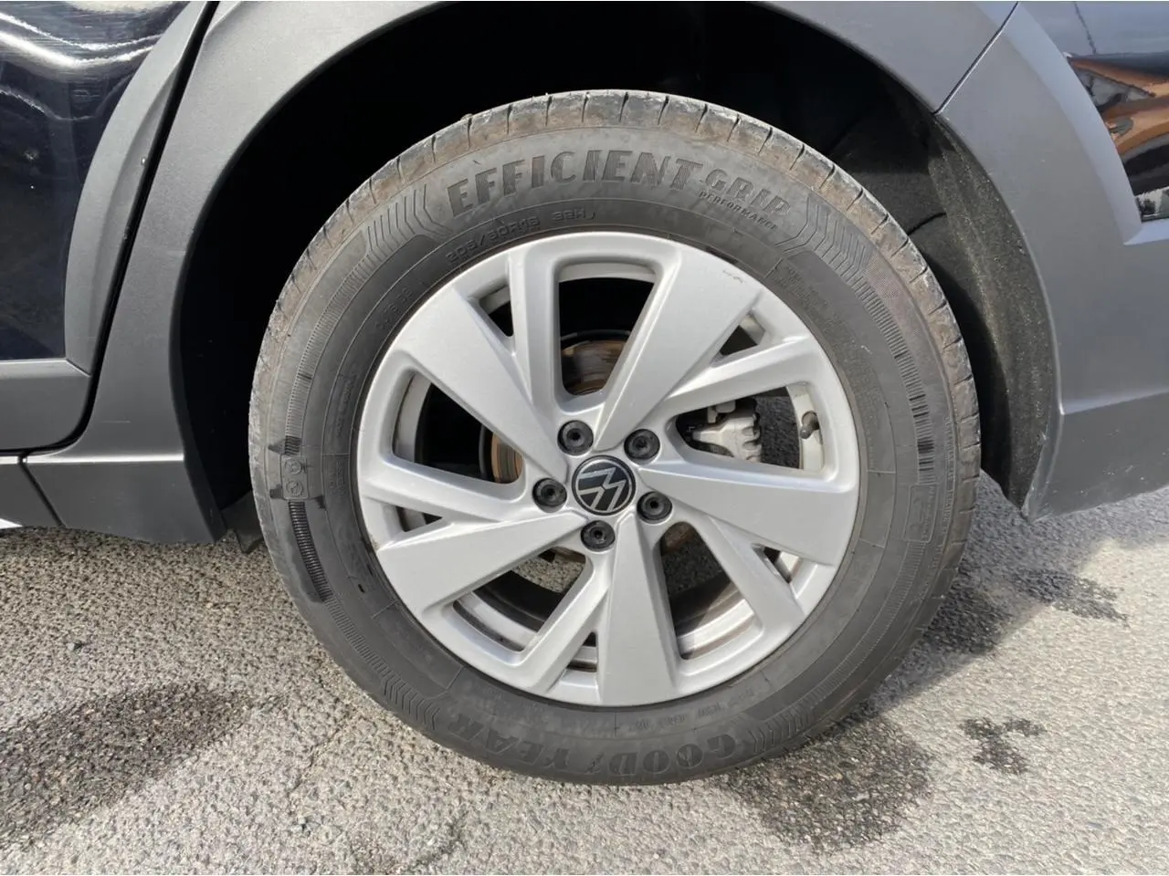 Gros plan sur la roue avant gauche du Volkswagen Taigo noir intense, mettant en valeur la jante alliage et le pneu Goodyear.