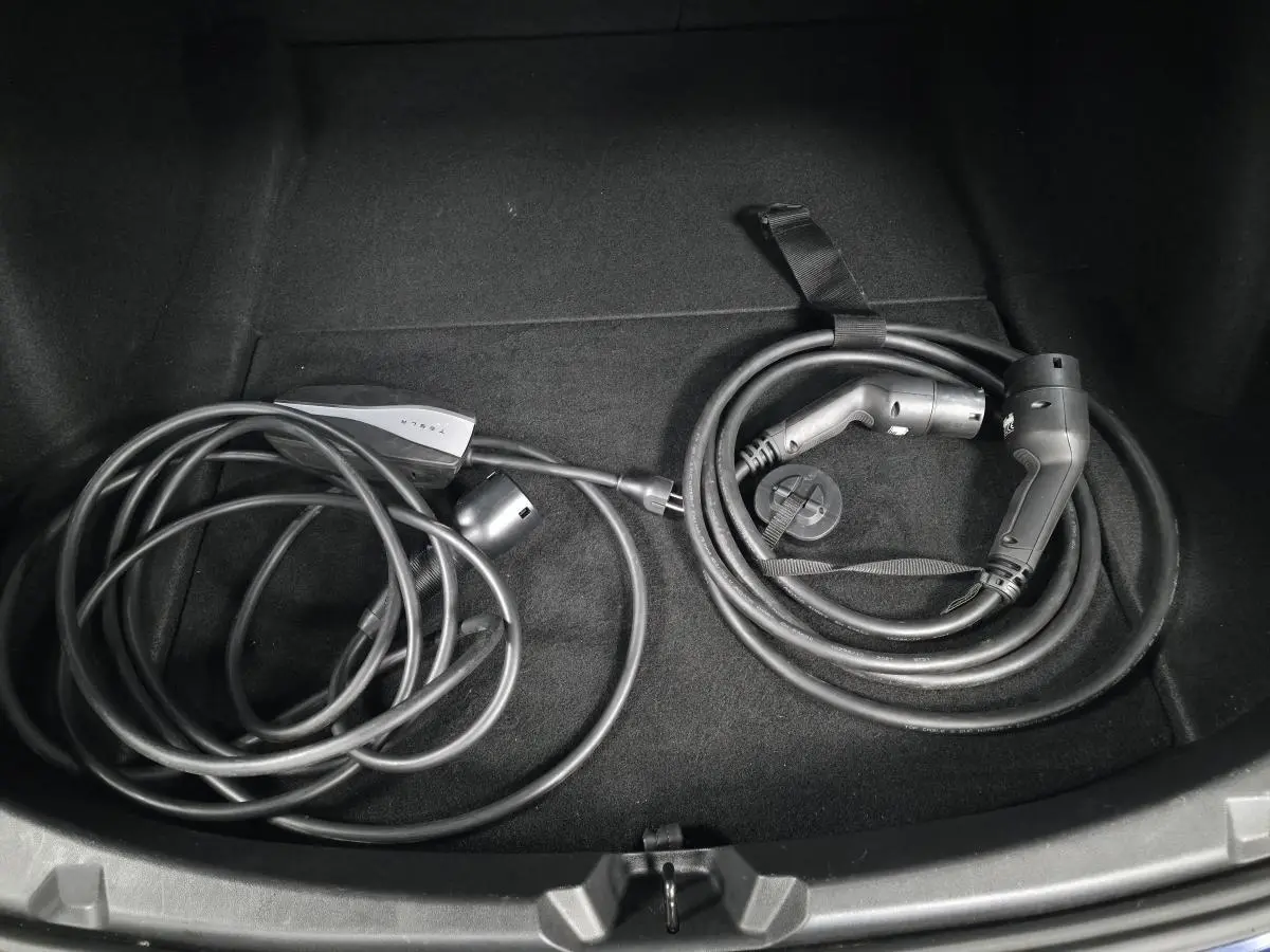Câbles de recharge électrique rangés dans le coffre d'une Tesla Model 3 RWD bleu foncé 2021.