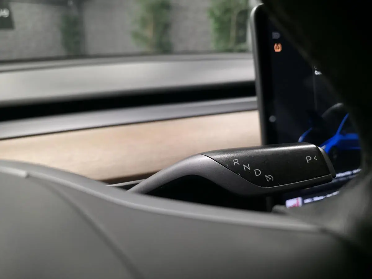 Le levier de boîte automatique noir de la Tesla Model 3 2021 RWD, vu en gros plan côté droit du volant.