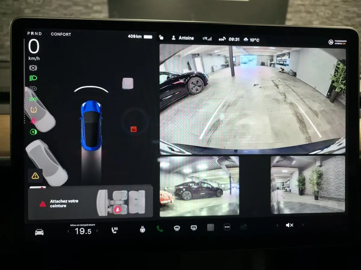 Écran tactile de la Tesla Model 3 RWD bleu foncé montrant la caméra 360° et l'affichage de la vitesse à 0 km/h.