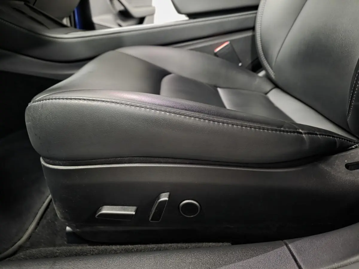 Gros plan sur le siège conducteur en cuir noir avec commandes électriques de la Tesla Model 3 RWD 2021.