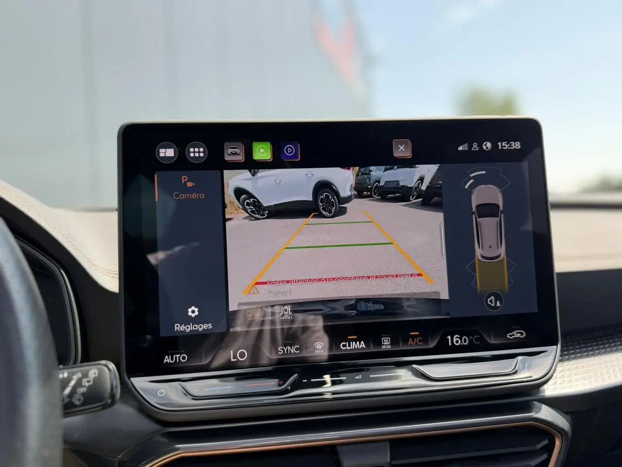 Écran tactile intérieur montrant la caméra de recul avec vue arrière d’un CUPRA Formentor blanc Neige.