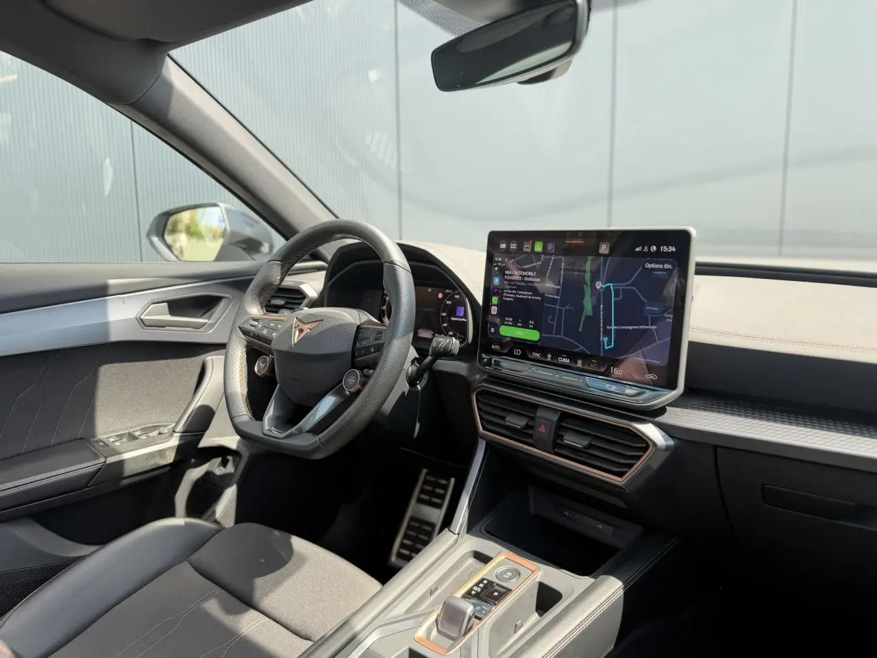 Vue intérieure avant droite du CUPRA Formentor blanc neige, avec tableau de bord numérique et écran tactile central lumineux.