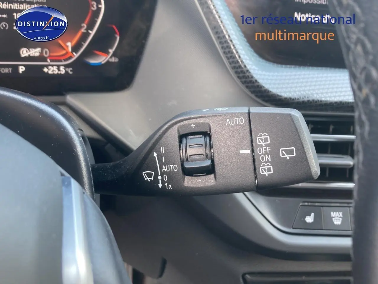 Gros plan sur la commande des essuie-glaces à gauche du volant dans l'habitacle d'une BMW Série 1 gris foncé 2023.