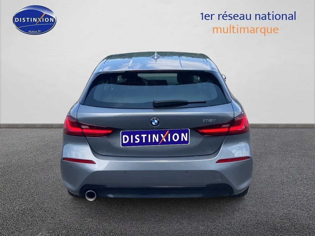 Vue arrière d'une BMW Série 1 118i gris foncé avec feux LED et sortie d'échappement unique côté gauche.