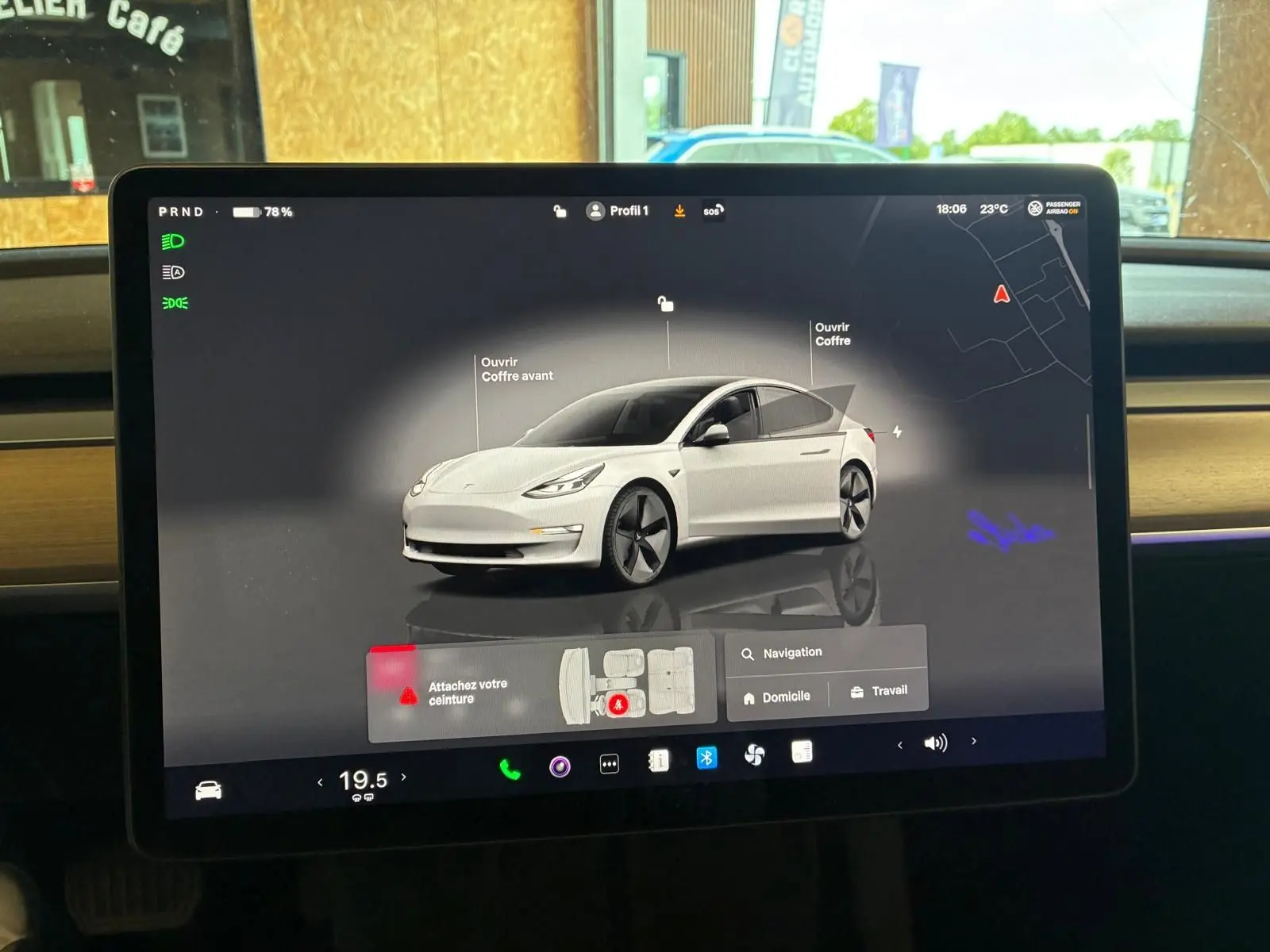 Écran tactile intérieur montrant une Tesla Model 3 blanc en vue 3/4 avant avec options d'ouverture des coffres.