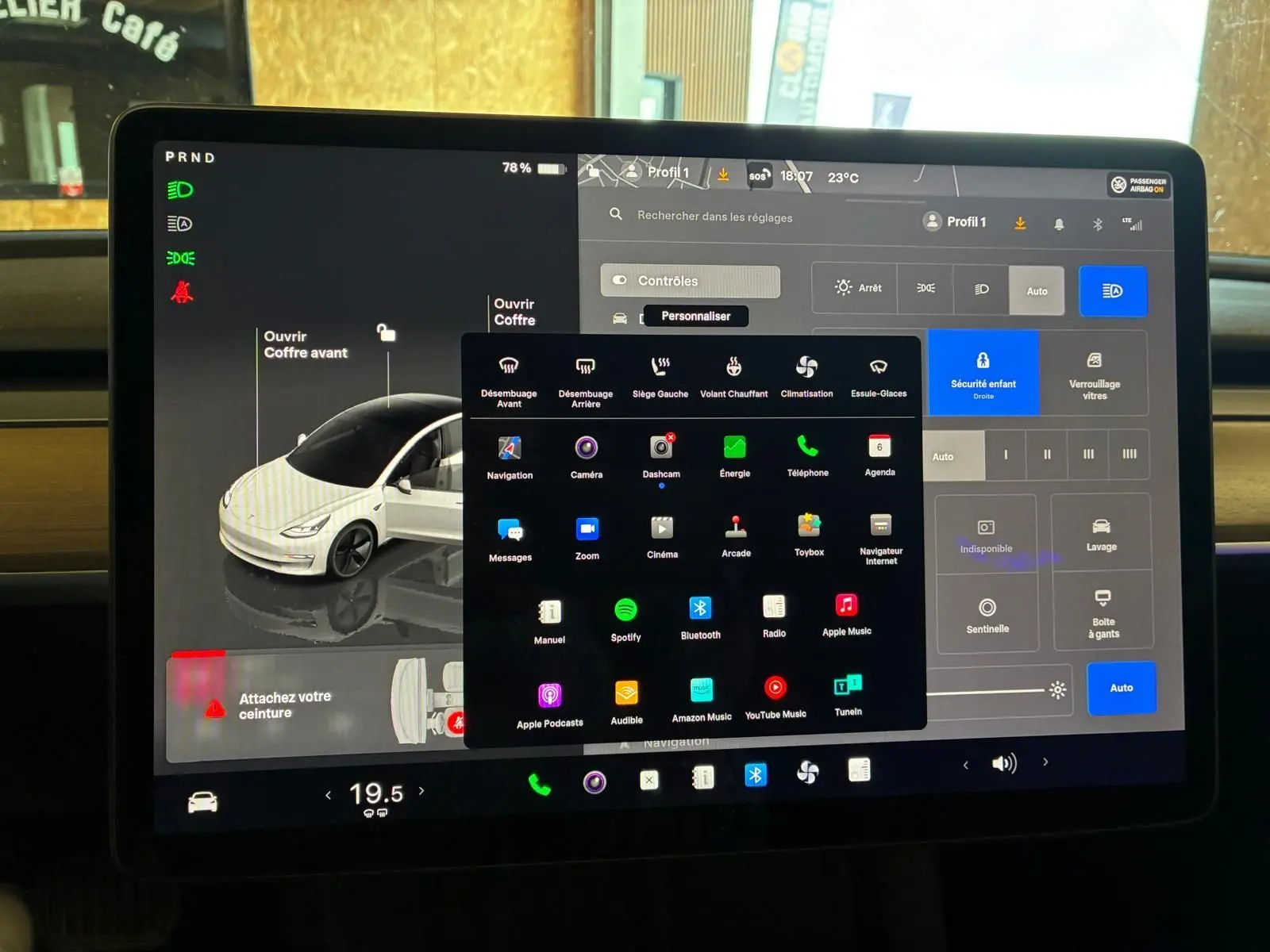 Écran tactile central de Tesla Model 3 blanc 2023, vue rapprochée montrant l'interface de contrôle et les options du véhicule.