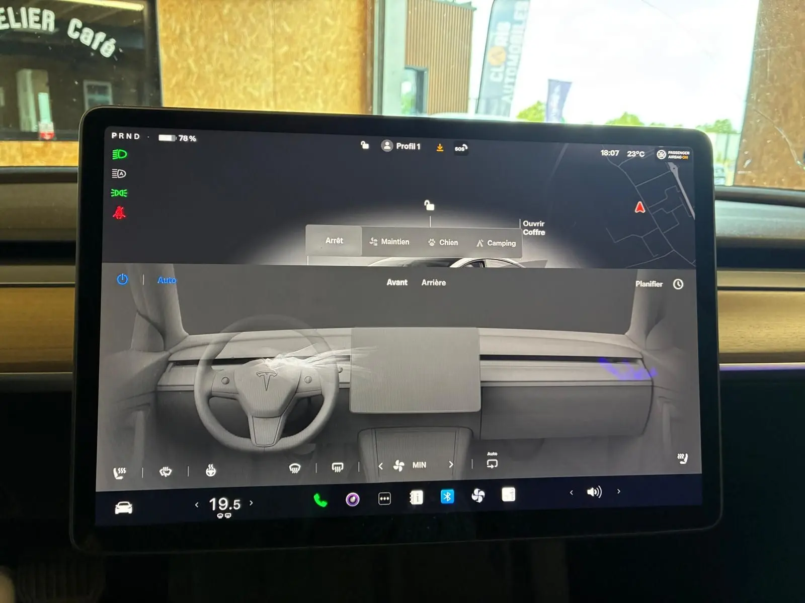 Écran central tactile affichant l'interface de contrôle du Tesla Model 3 blanc, vue intérieure frontale du tableau de bord.