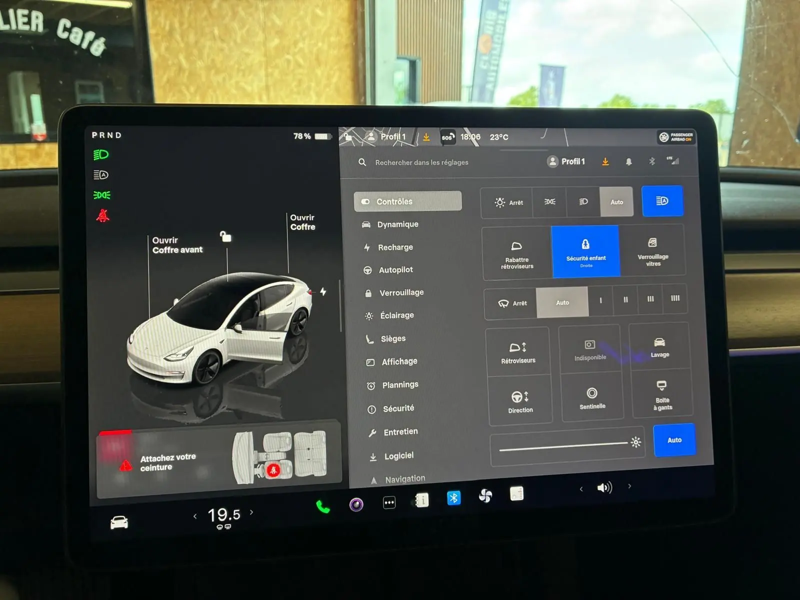Écran tactile intérieur de la Tesla Model 3 blanc, affichant les réglages du véhicule et l'ouverture des portes.
