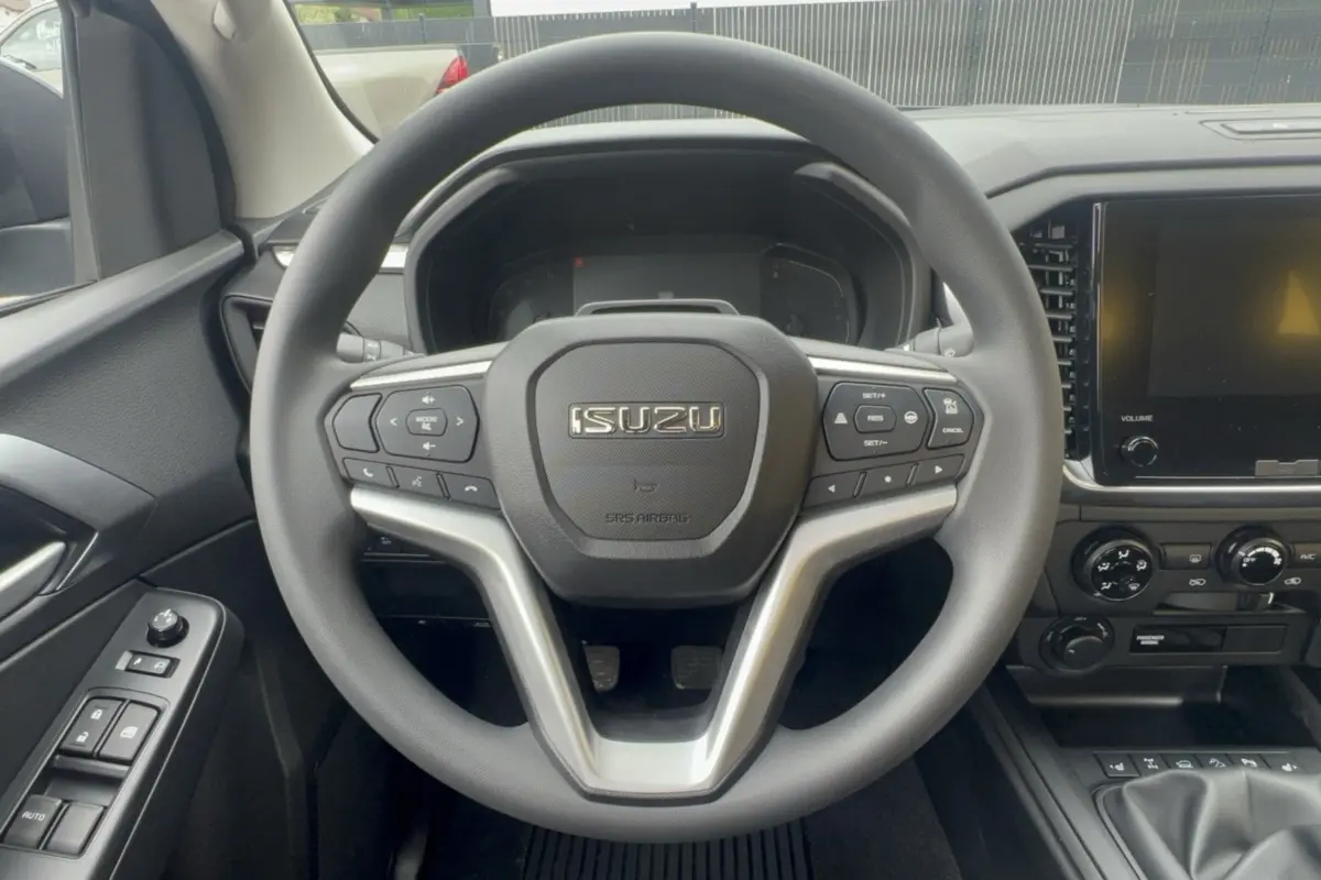 Vue centrée sur le volant multifonctions noir de l'Isuzu D-MAX 2026 avec tableau de bord et écran tactile.
