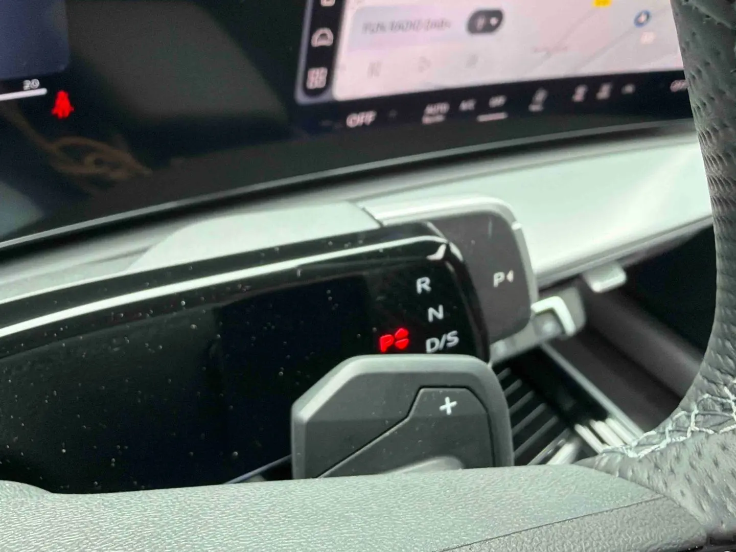 Gros plan sur la commande de boîte manuelle et palettes au volant de l'Audi Q3 Sportback gris, intérieur moderne.
