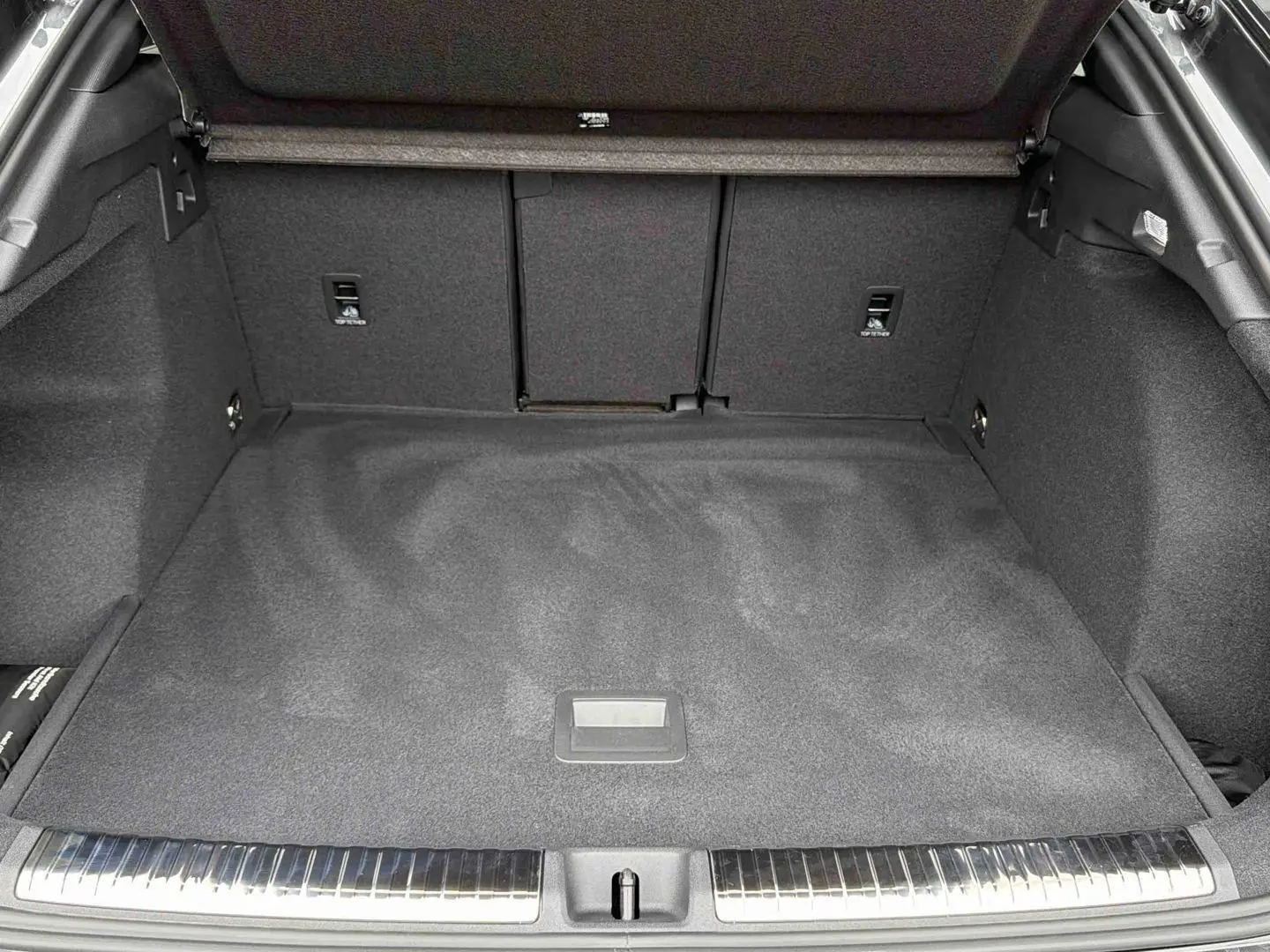 Coffre spacieux de l'Audi Q3 Sportback gris, vue de l'arrière avec seuil de chargement en acier inoxydable.