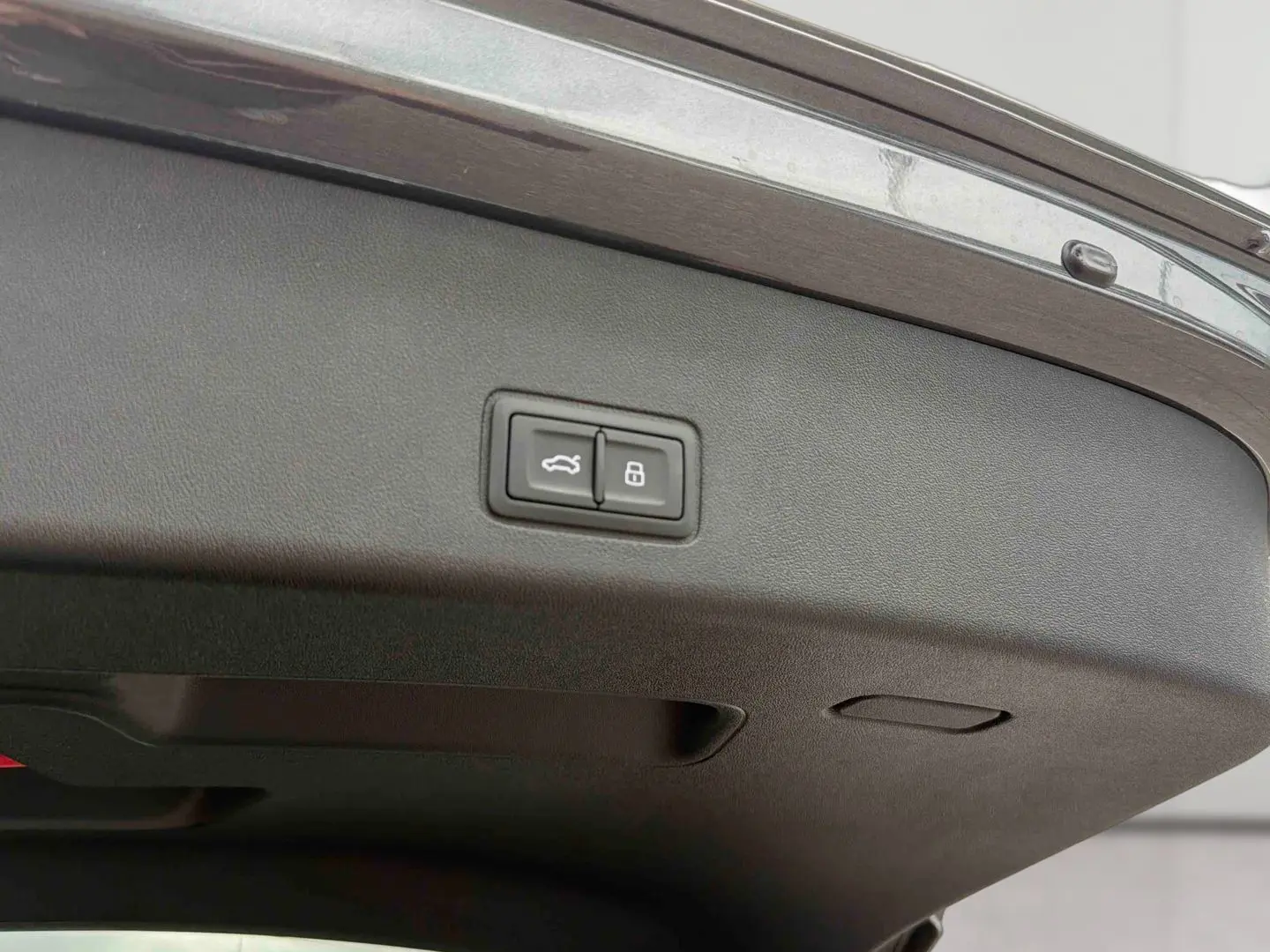 Gros plan sur la partie intérieure du hayon arrière gris de l'Audi Q3 Sportback avec boutons d'ouverture et verrouillage.