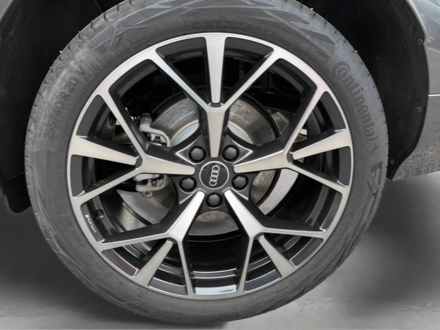 Gros plan sur la jante Audi Sport tripode noire et argentée du Q3 Sportback gris, avec pneu Continental 255/40 R20.