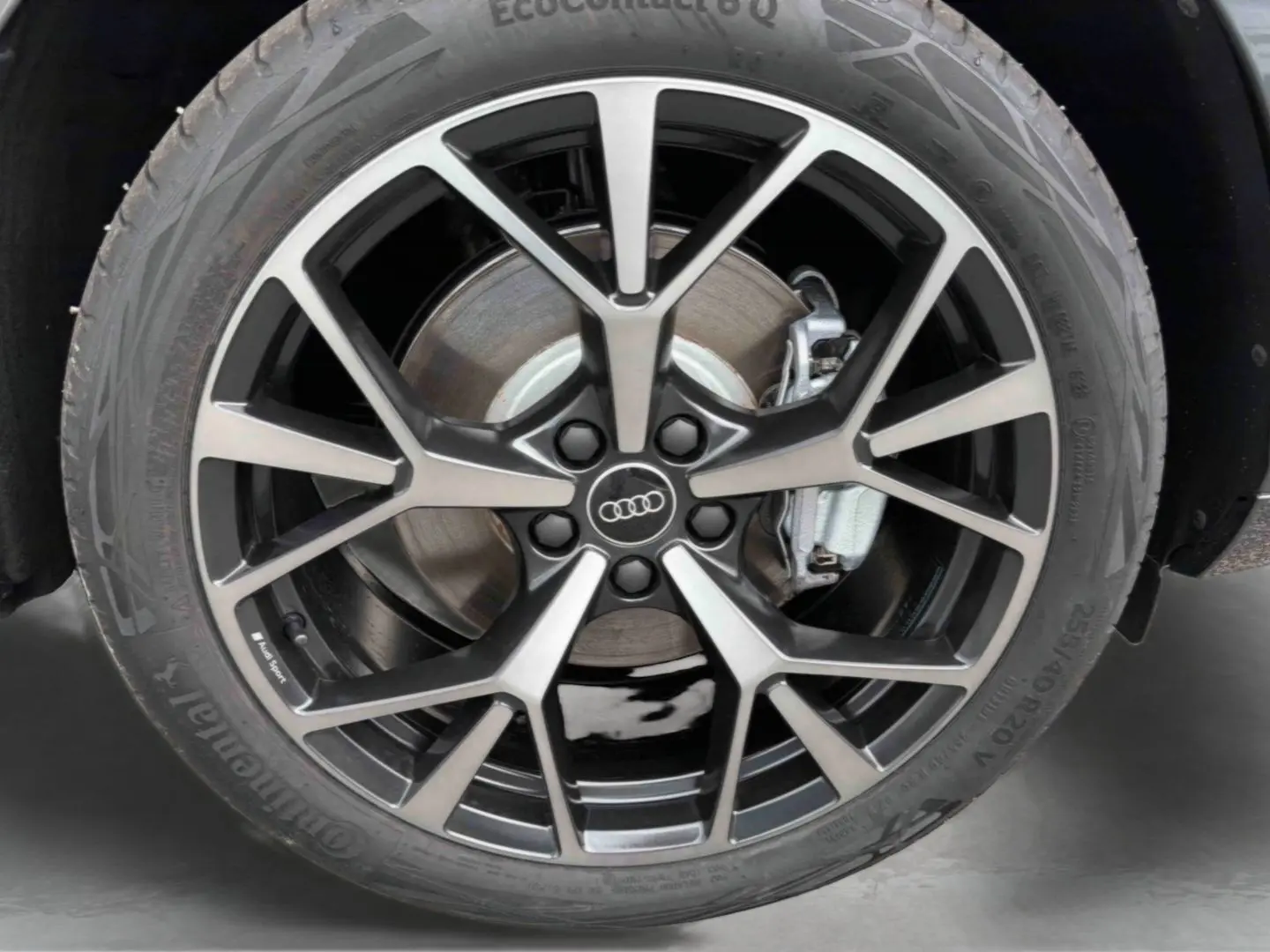 Gros plan sur la jante Audi Sport tripode noire métallisée 5 branches du Q3 Sportback gris avec frein visible.