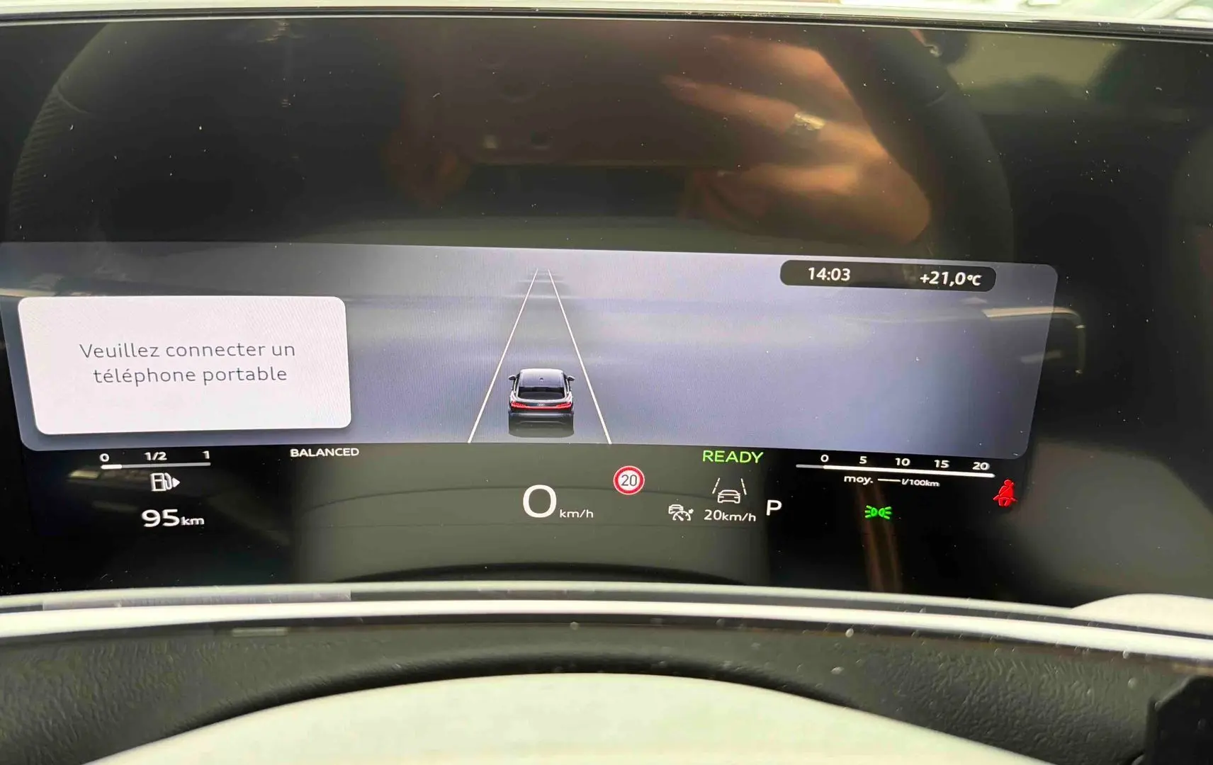 Vue rapprochée du combiné d'instruments numérique OLED de l'Audi Q3 Sportback gris affichant la vitesse et l'alerte de connexion téléphone.
