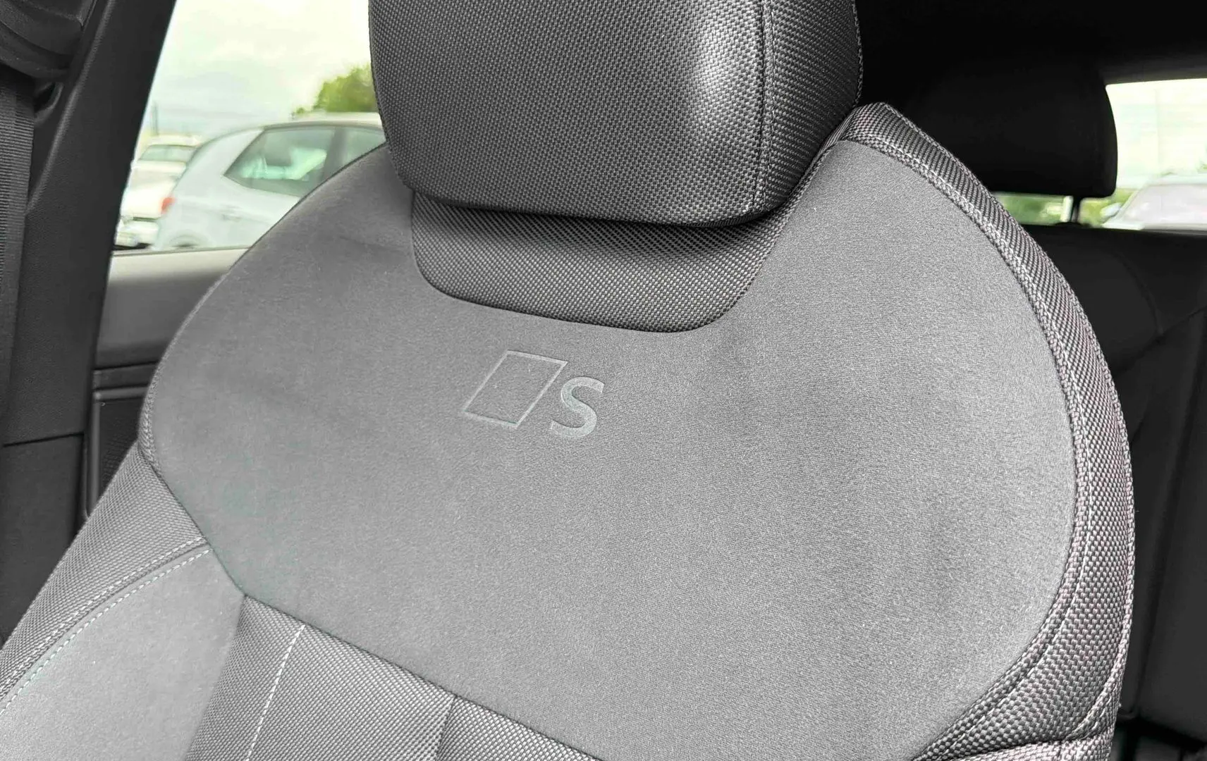 Gros plan sur le siège avant conducteur gris avec logo S embossé, intérieur Audi Q3 Sportback 2026.