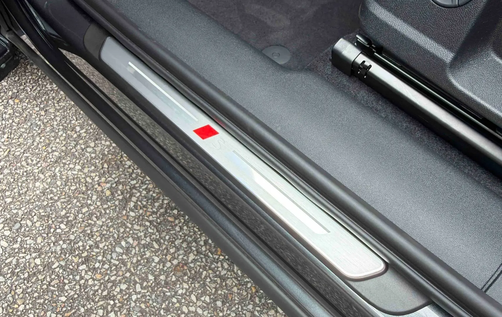 Seuil de porte avant gauche gris métallisé avec logo S sur Audi Q3 Sportback 2026, intérieur noir.