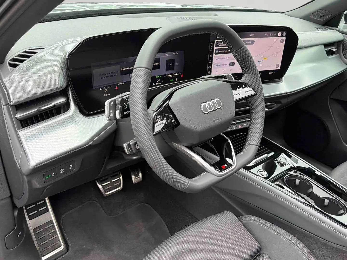 Vue intérieure côté conducteur de l'Audi Q3 Sportback gris, volant sport multifonctions et tableau de bord numérique OLED.