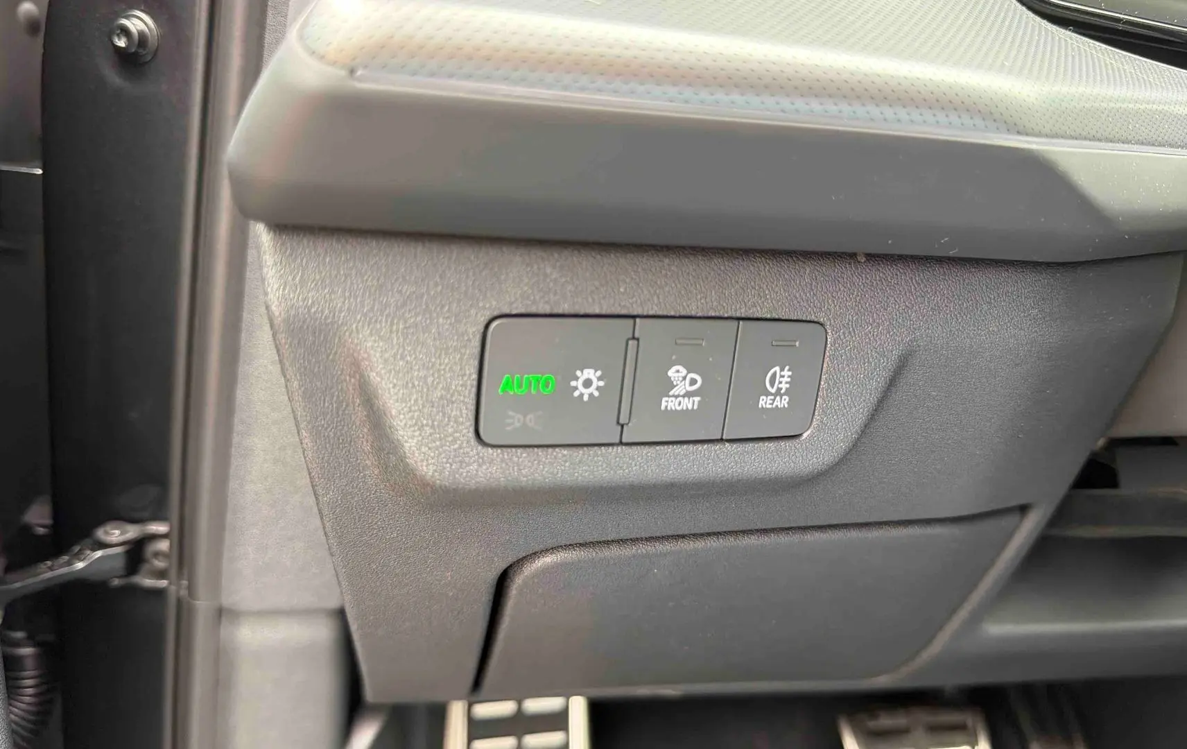 Gros plan sur les commandes d’éclairage avec bouton auto allumé dans l’habitacle de l’Audi Q3 Sportback gris.