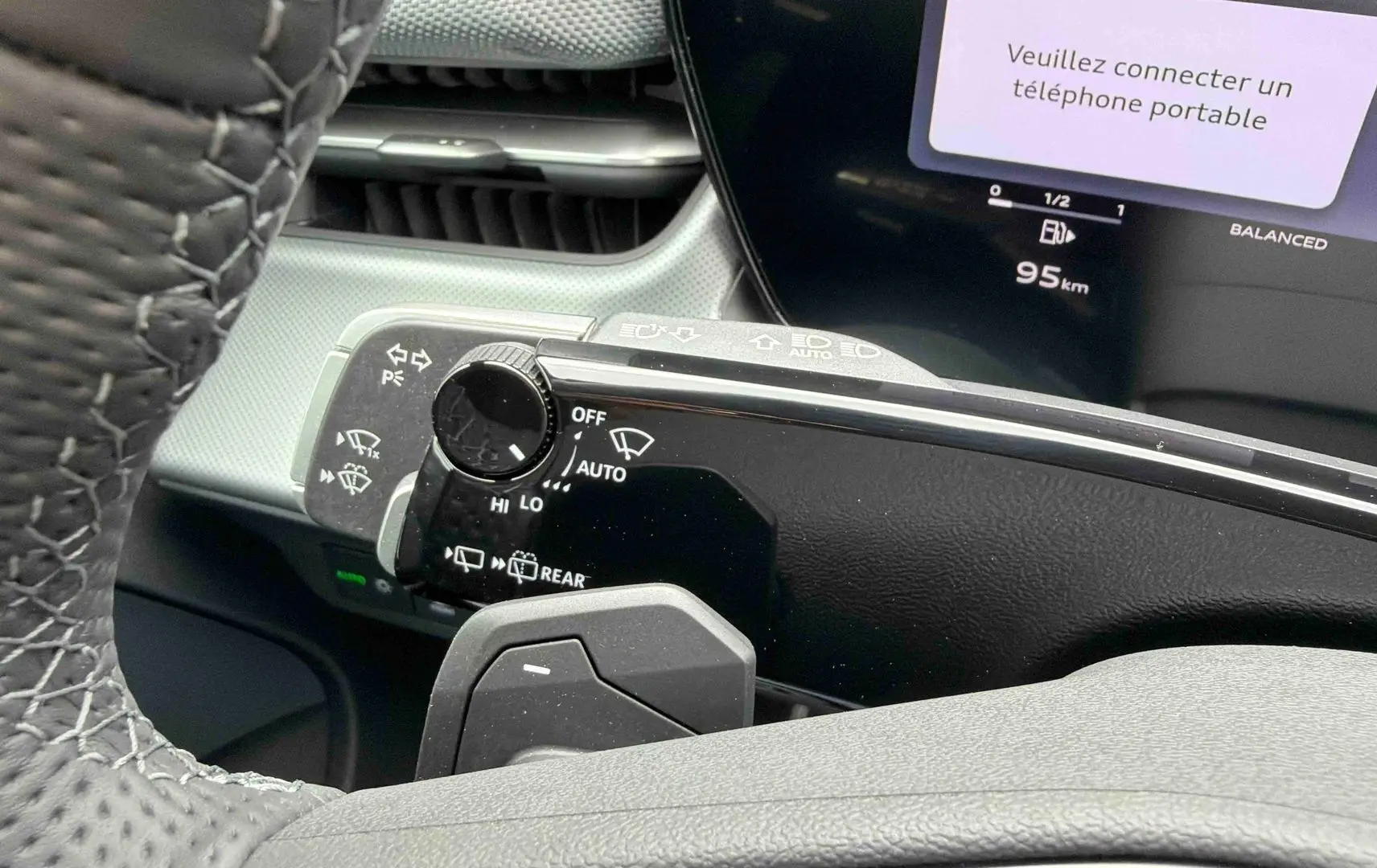 Gros plan sur la commande des essuie-glaces et le combiné numérique de l'Audi Q3 Sportback gris, intérieur moderne.