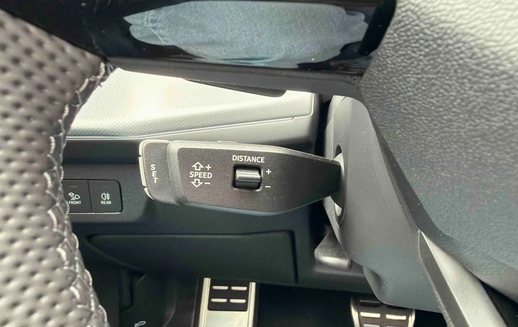 Gros plan sur la commande de régulateur de vitesse et la pédale en acier dans l’habitacle de l’Audi Q3 Sportback gris.