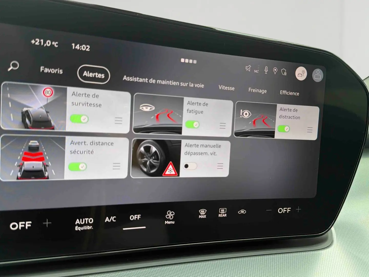 Écran tactile intérieur affichant les alertes d’assistance à la conduite sur Audi Q3 Sportback gris, vue de près.