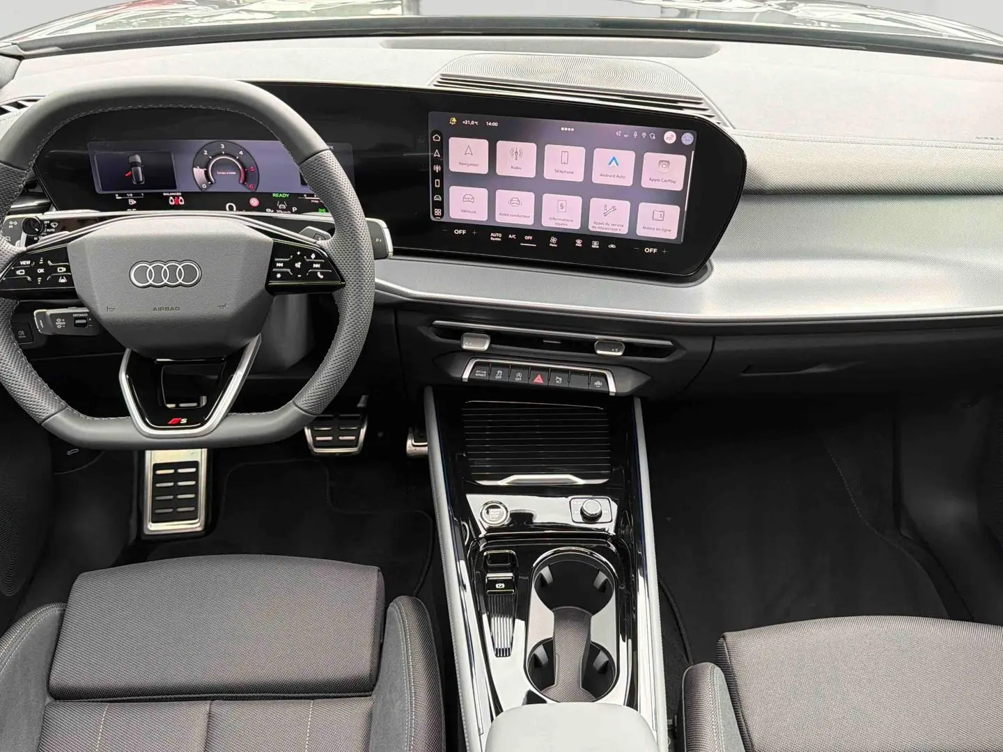 Vue intérieure du tableau de bord et console centrale noire de l'Audi Q3 Sportback avec écran tactile et volant sport multifonctions.