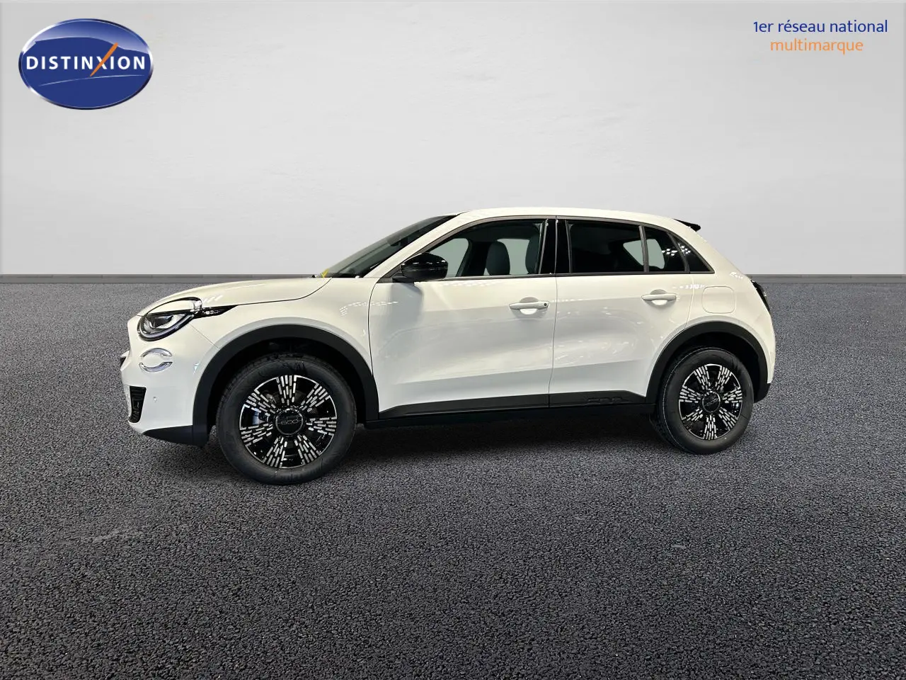 Profil droit d'une Fiat 600 blanche 2026 avec jantes alliage noires et coques de rétroviseurs noirs brillants.