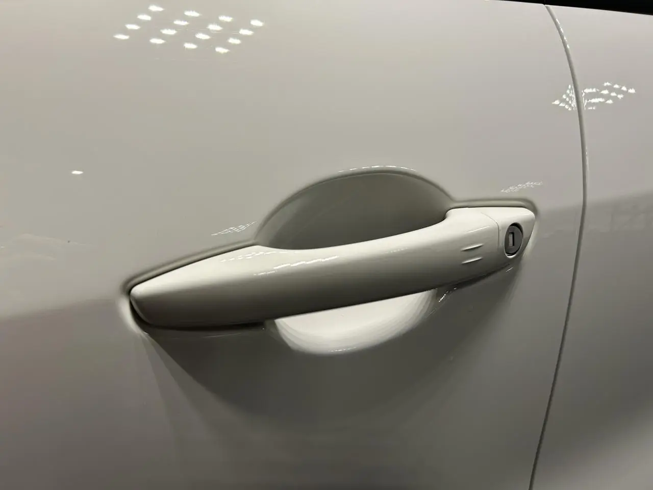 Poignée de porte blanche en gros plan sur le côté gauche d'une FIAT 600 hybride 2026.