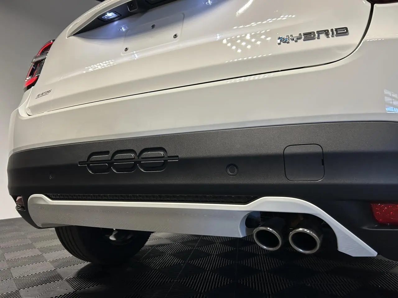 Vue rapprochée arrière droite de la FIAT 600 blanche avec logo Hybrid et double sortie d’échappement chromée.