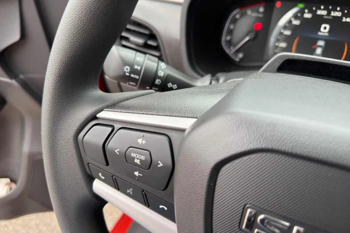Gros plan sur le volant multifonctions noir de l'Isuzu D-MAX 2026 avec commandes audio et téléphone intégrées.