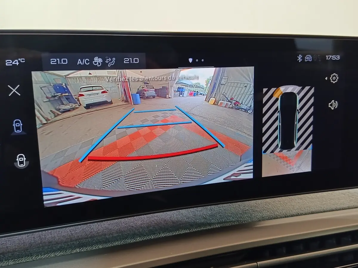 Écran tactile intérieur montrant la caméra de recul et l’aide au stationnement du Peugeot 5008 gris clair, vue arrière.