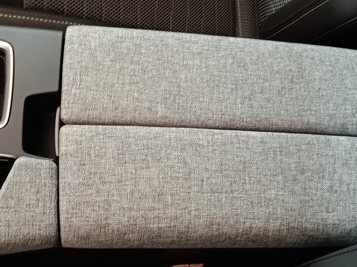 Détail de l’accoudoir central en tissu gris clair à l’intérieur du Peugeot 5008 1.6 PHEV 195 E-DCS7 GT 2026.