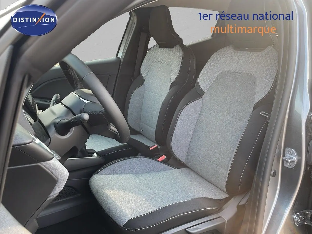 Vue intérieure côté conducteur de la Renault Clio 2025 gris schiste métal avec sièges tissu gris et noir détaillés.