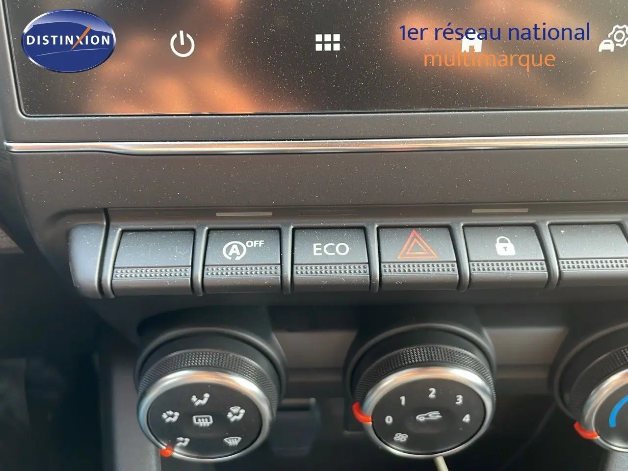 Gros plan sur la console centrale de la Renault Clio gris schiste, montrant les boutons de commande et les réglages climatiques.