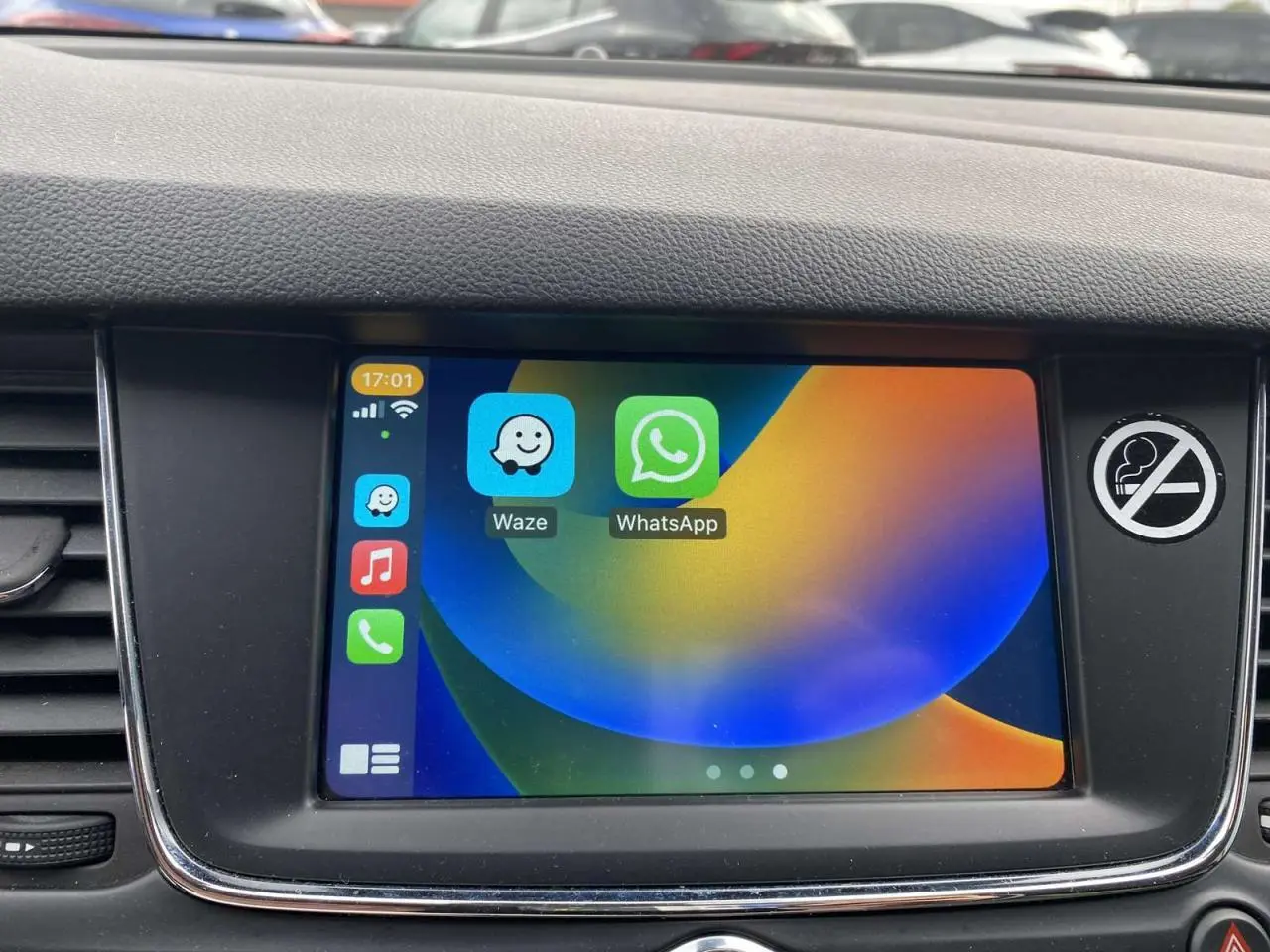 Écran tactile 7 pouces de l'Opel Astra 2021 affichant les applications Waze et WhatsApp, entouré de la console noire.