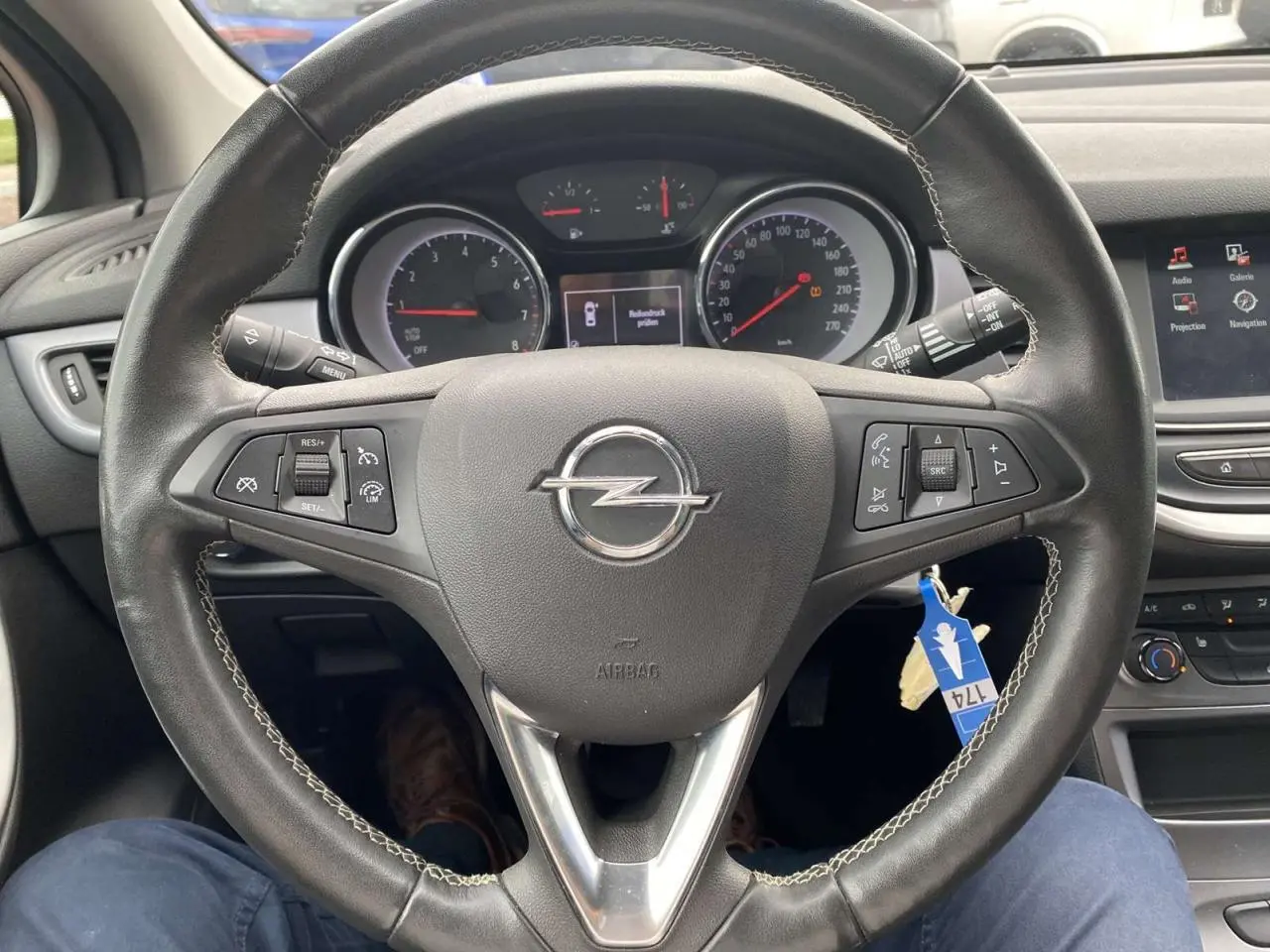 Vue intérieure centrée sur le volant noir de l'Opel Astra 2021 avec tableau de bord et écran tactile visible.