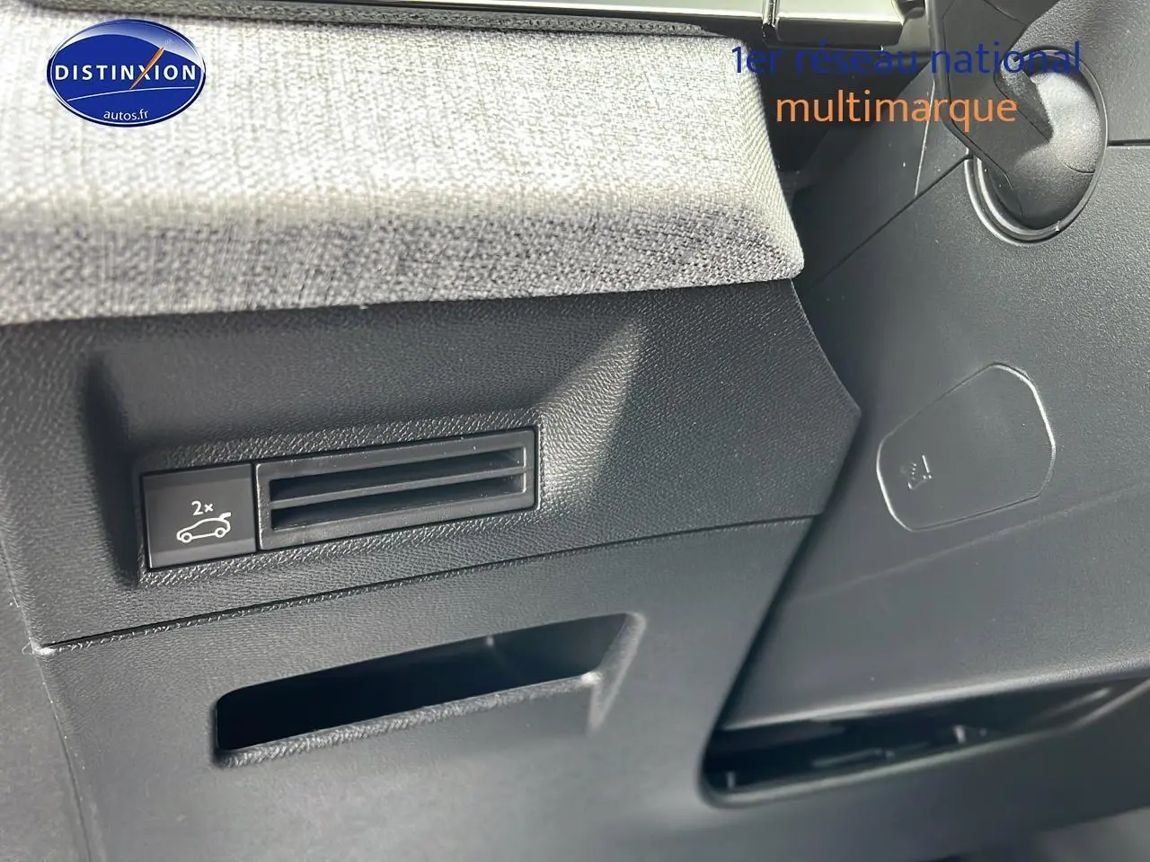 Détail du tableau de bord côté gauche du Peugeot 3008 gris, montrant la commande d'ouverture du coffre et la finition tissu.